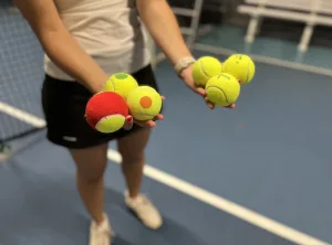 Different types of tennis balls in player's hand