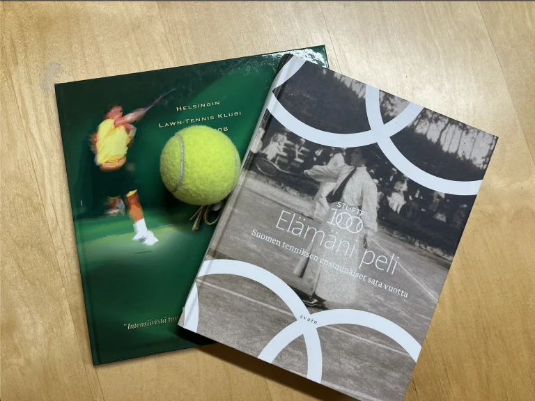 Two tennis books and a tennis ball on a table