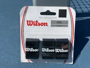 Wlson Feel Tennis Overgrip package on a tennis court
